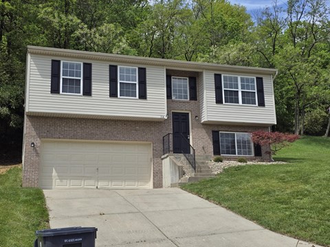 a white house with black shutters and a driveway